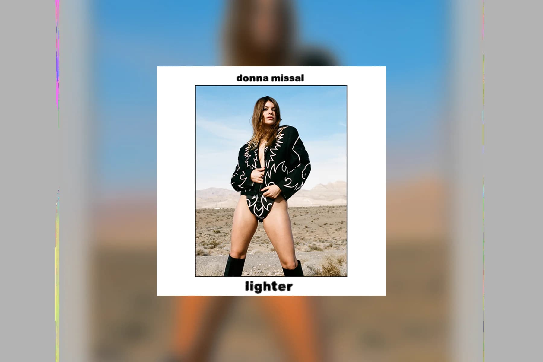 The album cover for Donna Missal's Lighter showing Missal standing in a black embroidered jacket against a desert landscape